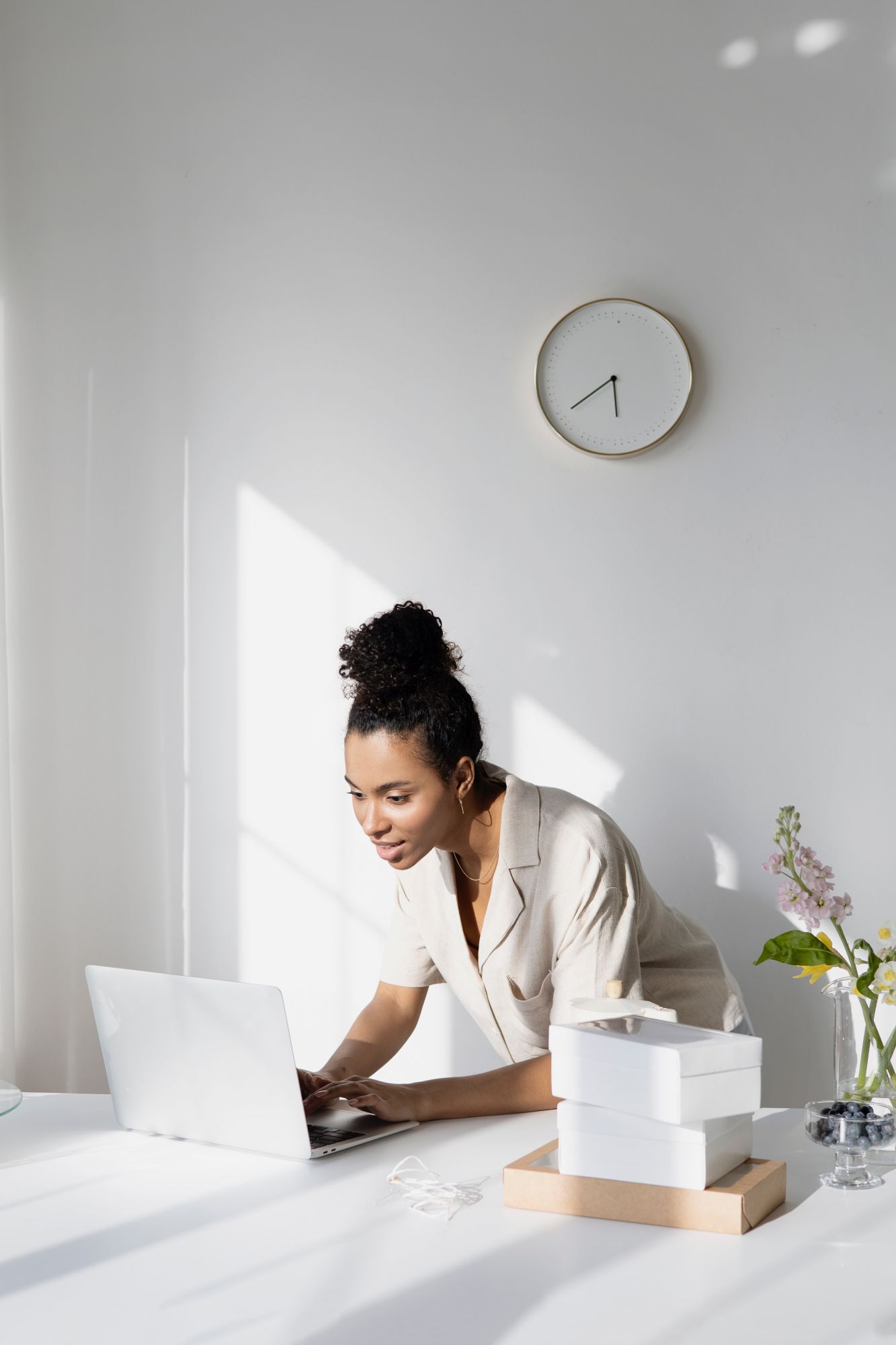 Woman looking down at her laptop in home office.